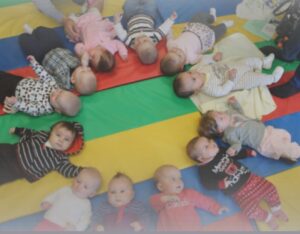Image of babies on a play mat, placed in a cirlce.