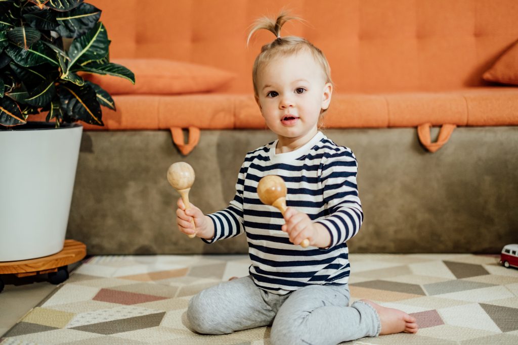 Toddler playing the maracas at a fun music class.